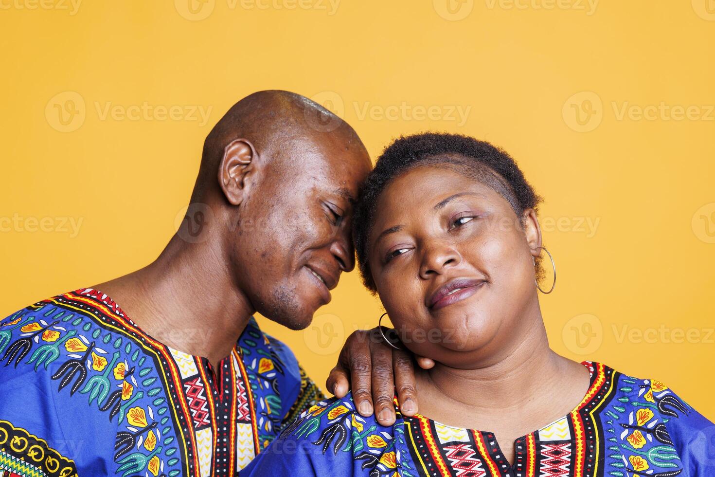 African american man and woman couple posing together, showing relationship bonding and love. Happy smiling husband leaning to wife with closed eyes, embracing and enjoying romance photo