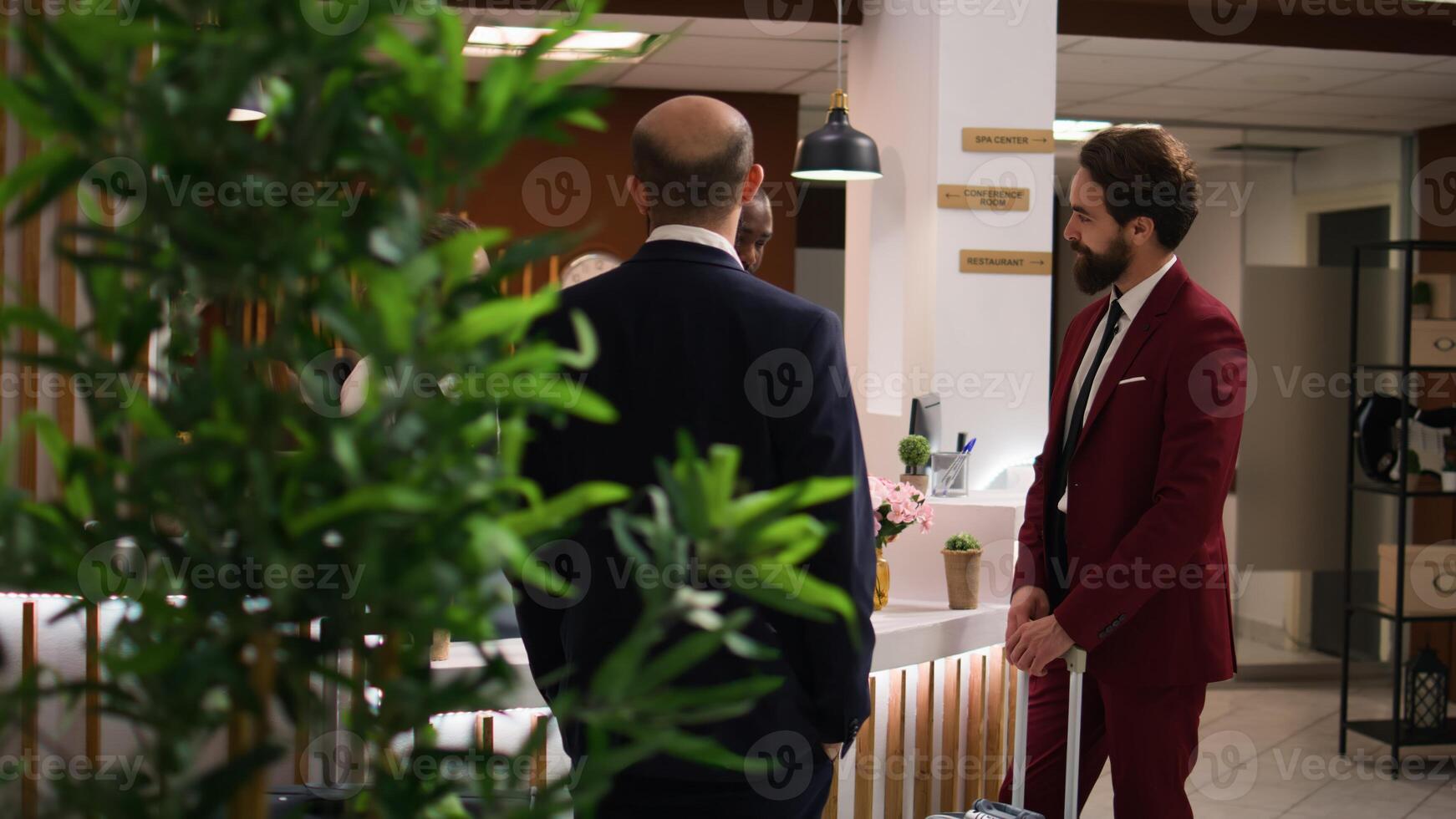 Entrepreneur chats with receptionist in lobby, expressing gratitude to hotel staff members for luxury assistance and services. Businessman appreciating easy check in process on work trip. photo