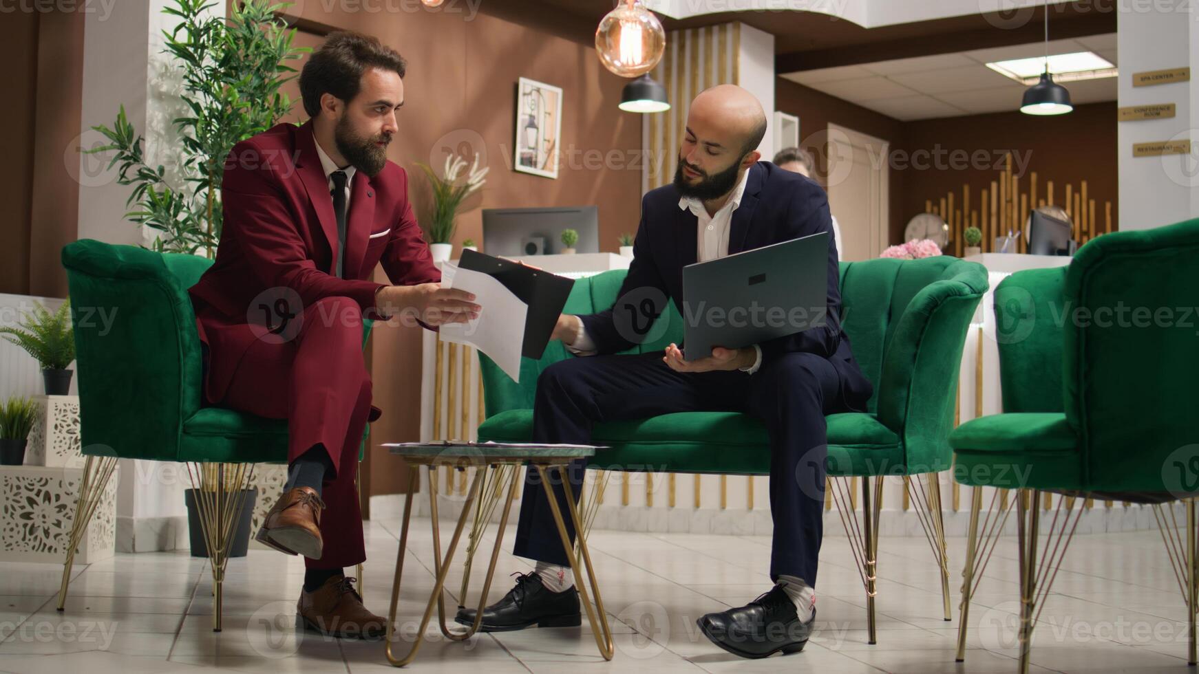 Coworkers share different business practises during international investors meeting at hotel lobby lounge area. Partners creating collaboration together, exchanging growth thoughts. Handheld shot. photo