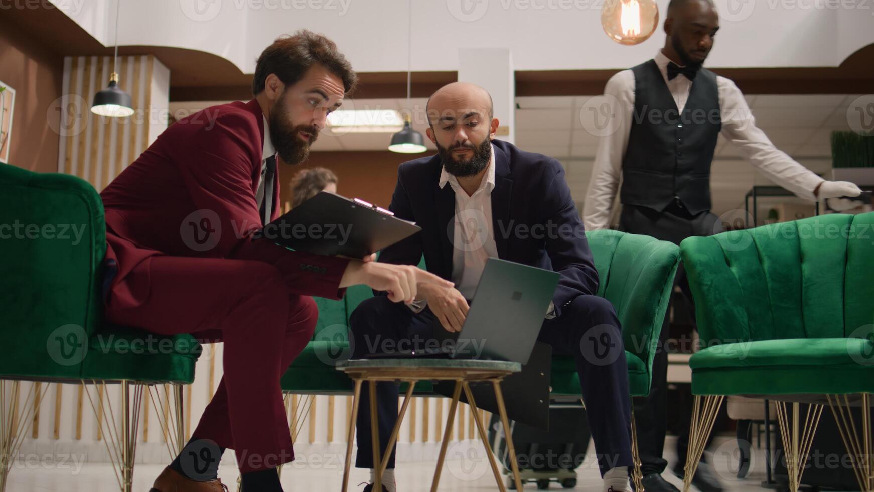 Entrepreneurs meet in hotel lobby, looking over finacial data on files before presenting statistics on official meeting. Associates discussing about partnership and sharing ideas for common goal. photo