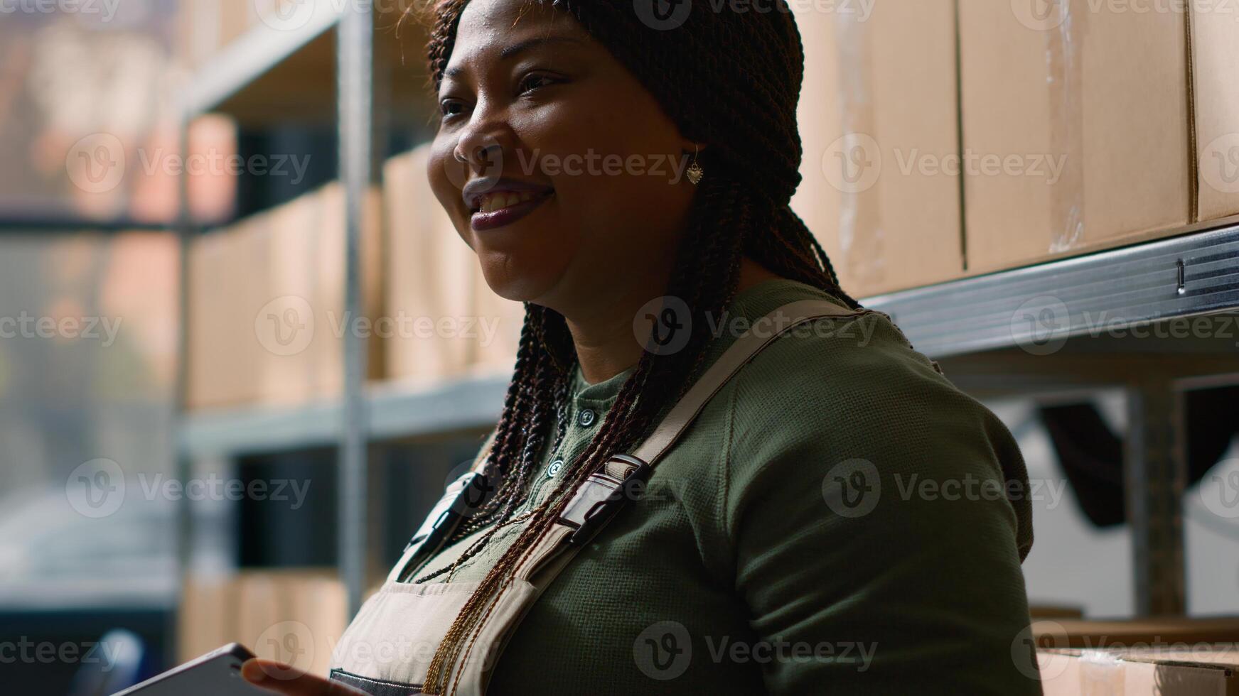 Close up shot of african american warehouse logistics director holding tablet, checking packaged cardboard boxes parcels, ensuring optimal operations in professional storage depository photo