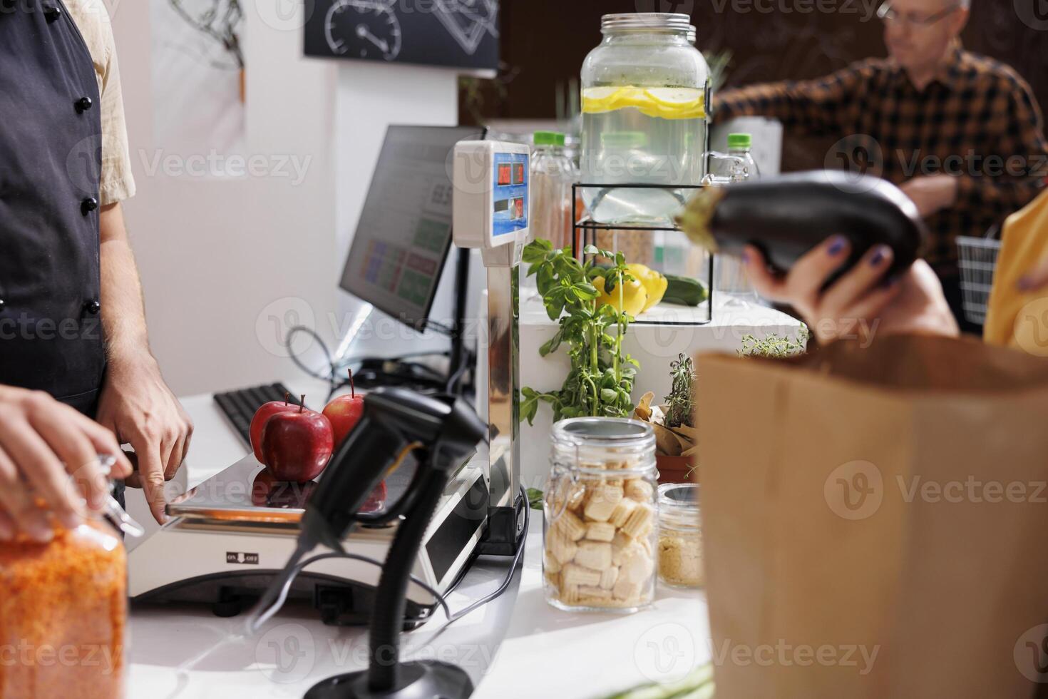 Close up of merchant at checkout counter in zero waste shop selling vegan products to environmentally conscious customers. Client buys healthy food with no additives in local neighborhood store photo