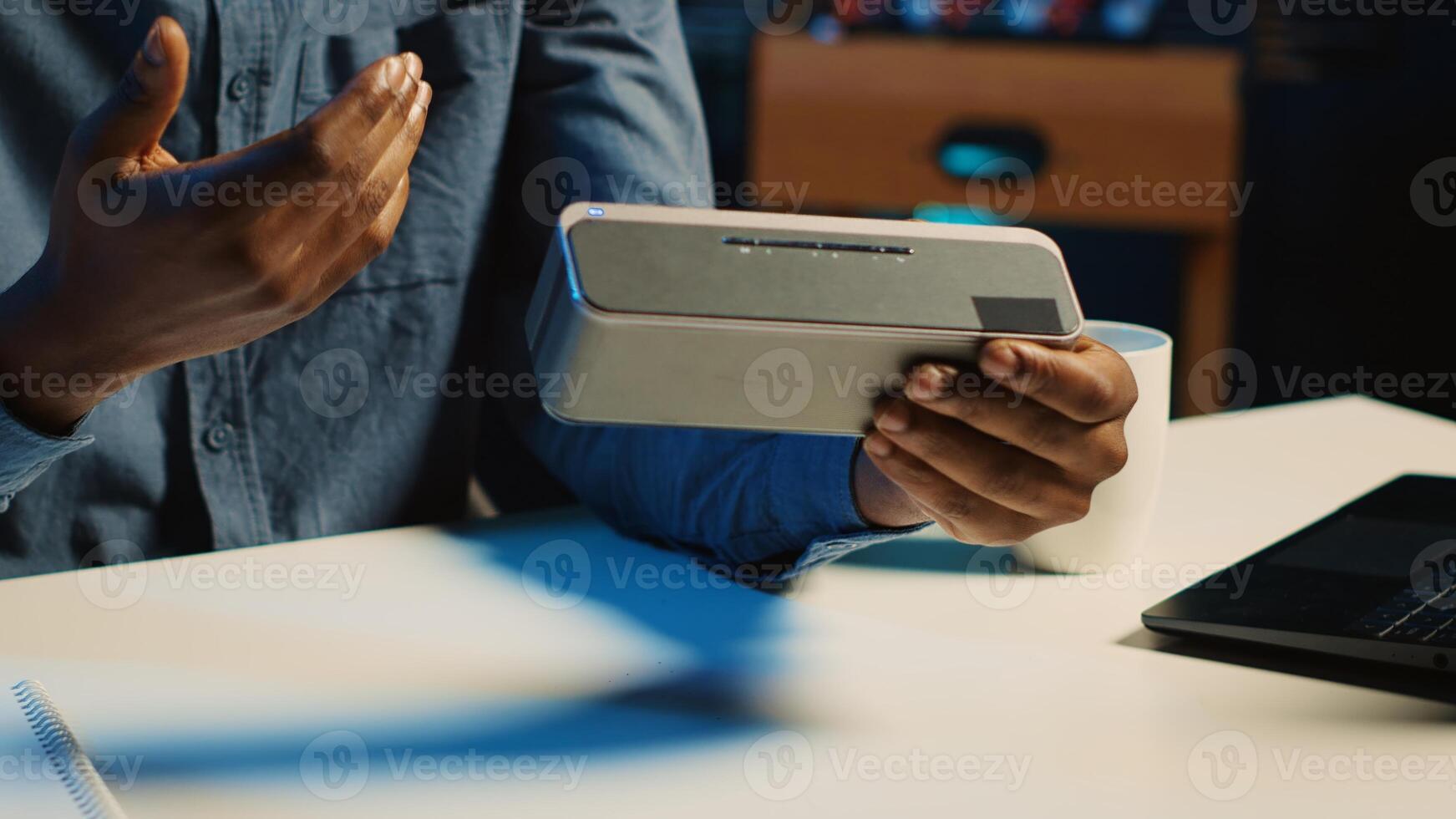 Close up shot of portable speaker used by content creator doing technology reviews for his online platforms channel. Influencer presents music playing device to his audience photo