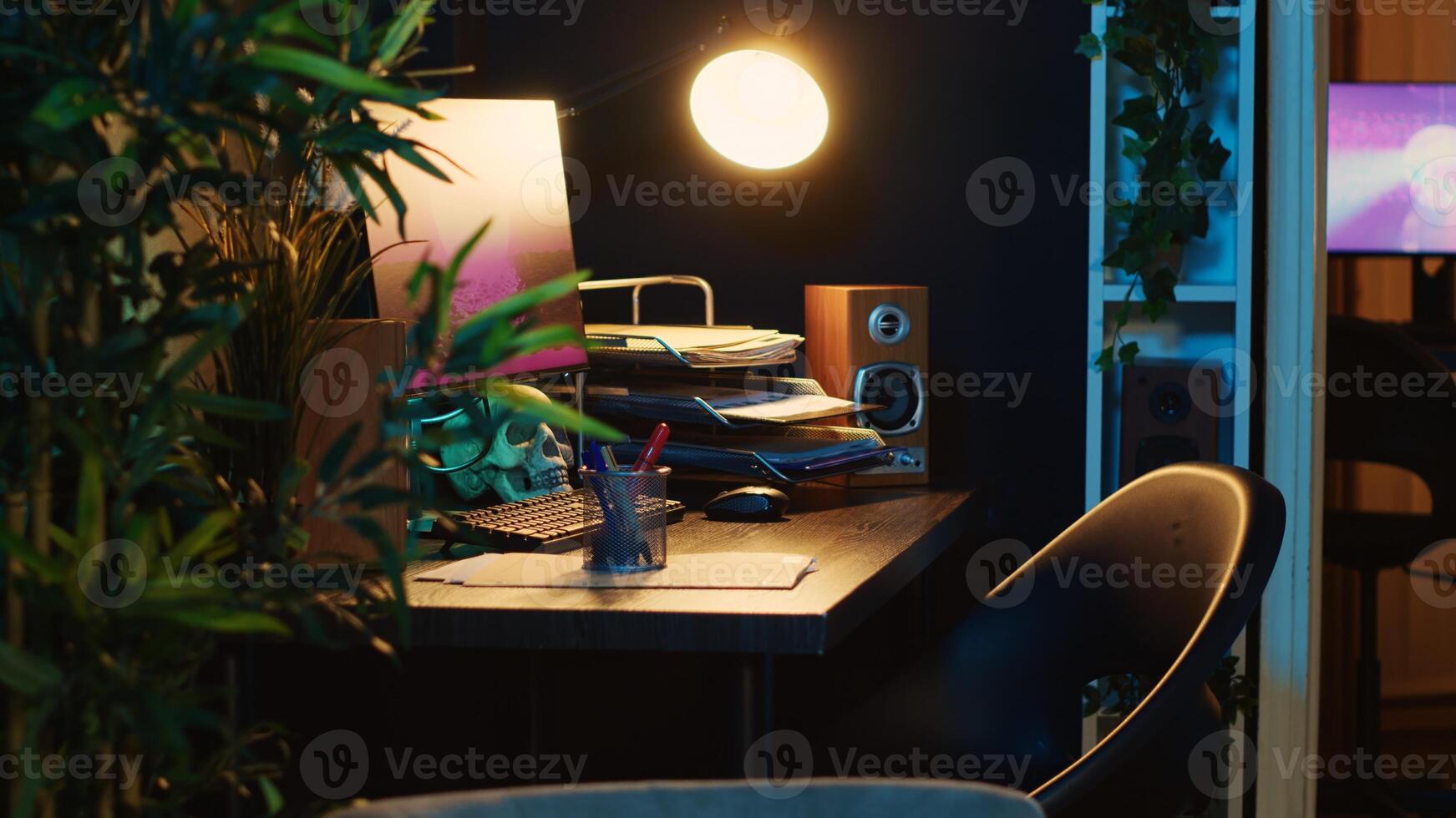 Revealing shot of computer screens showing running animation rendering in dimly lit empty home interior. 3D renders on digital displays on cozy apartment living room work desk photo