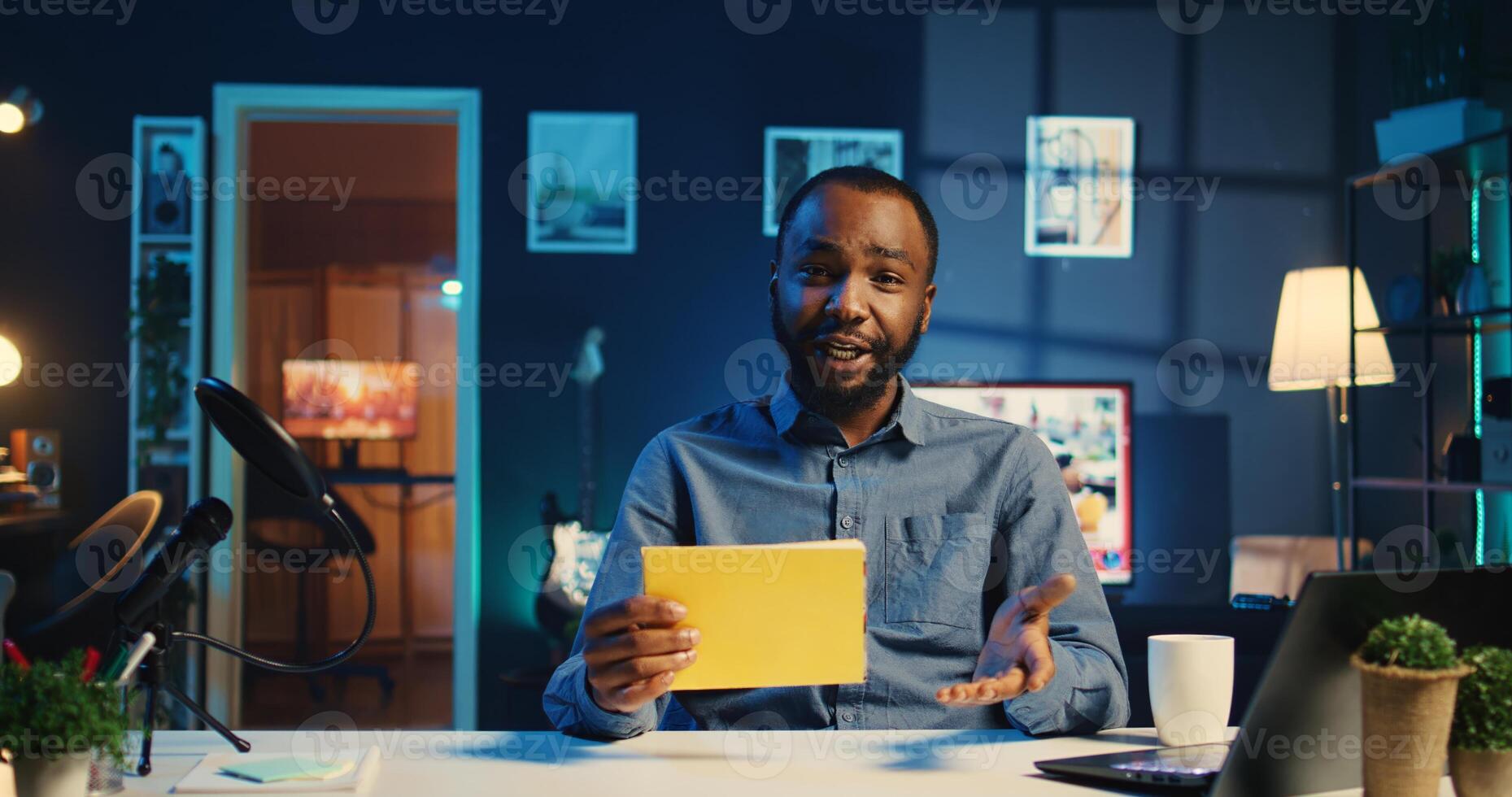 Happy BIPOC content creator films video review of book, browsing through pages, presenting synopsis to audience. Media star sponsored by publisher to show new novel release to readers photo