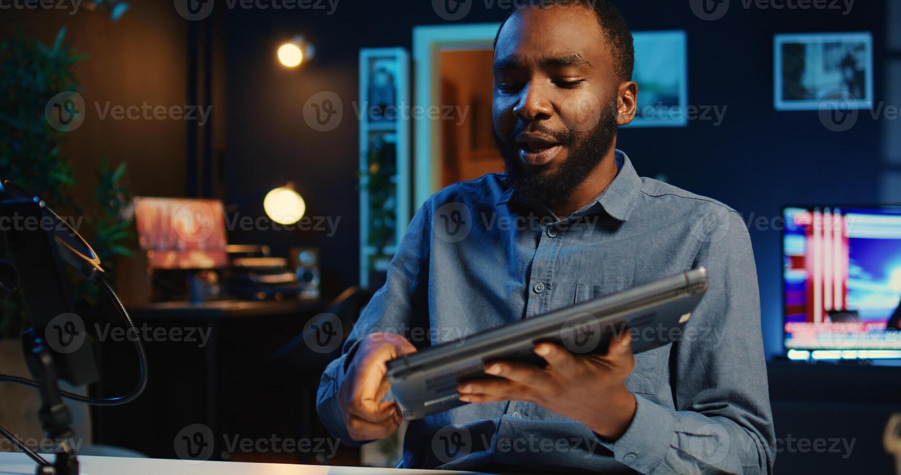 Online star films review of newly released laptop, unboxing it and presenting specs to audience. Influencer showing ultra slim notebook to fans, offering feedback of its performance photo