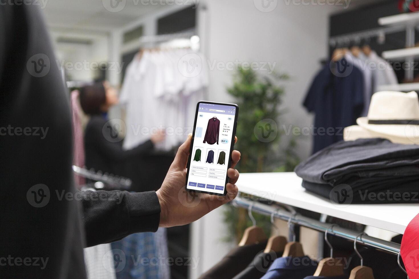 In a contemperory boutique, a caucasian customer holds a digital device. Stylish male shopper using modern technology to browse for fashionable merchandise in a clothing store. photo