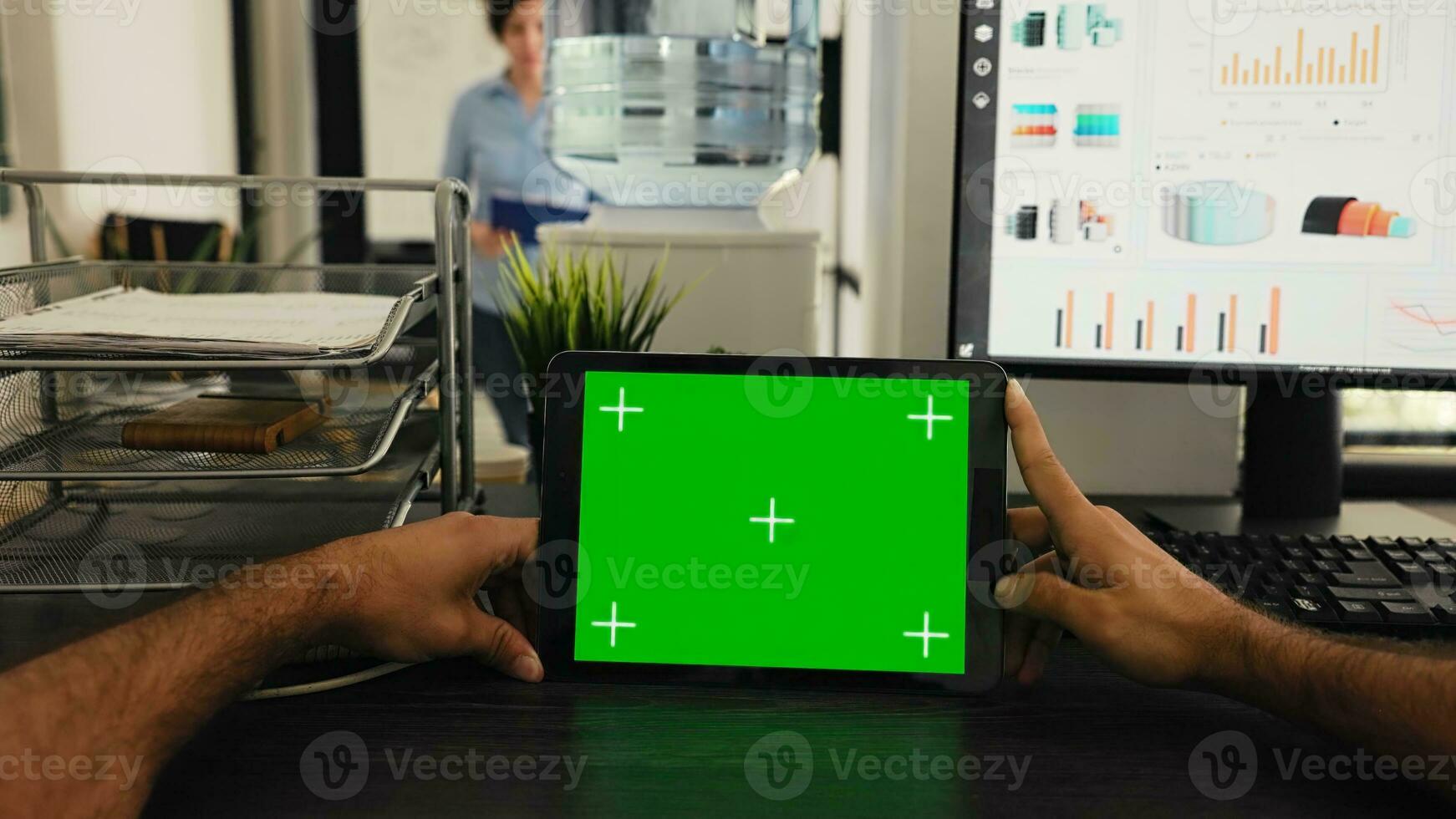 POV of manager uses tablet with greenscreen template, looking at chromakey layout and sitting in coworking space. Young man examining blank mockup copyspace on device display. photo