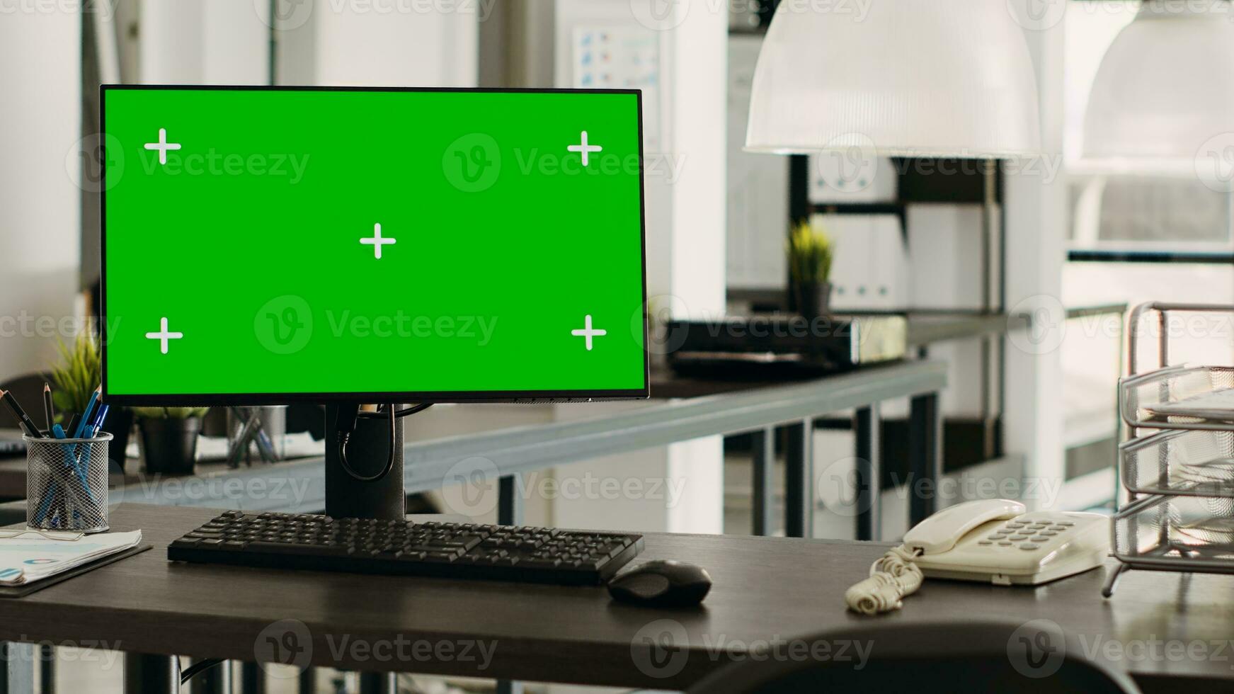 Greenscreen desktop in coworking space pc placed on workstation, open floor plan business office. Computer monitor showing isolated chromakey template with blank mockup display. photo