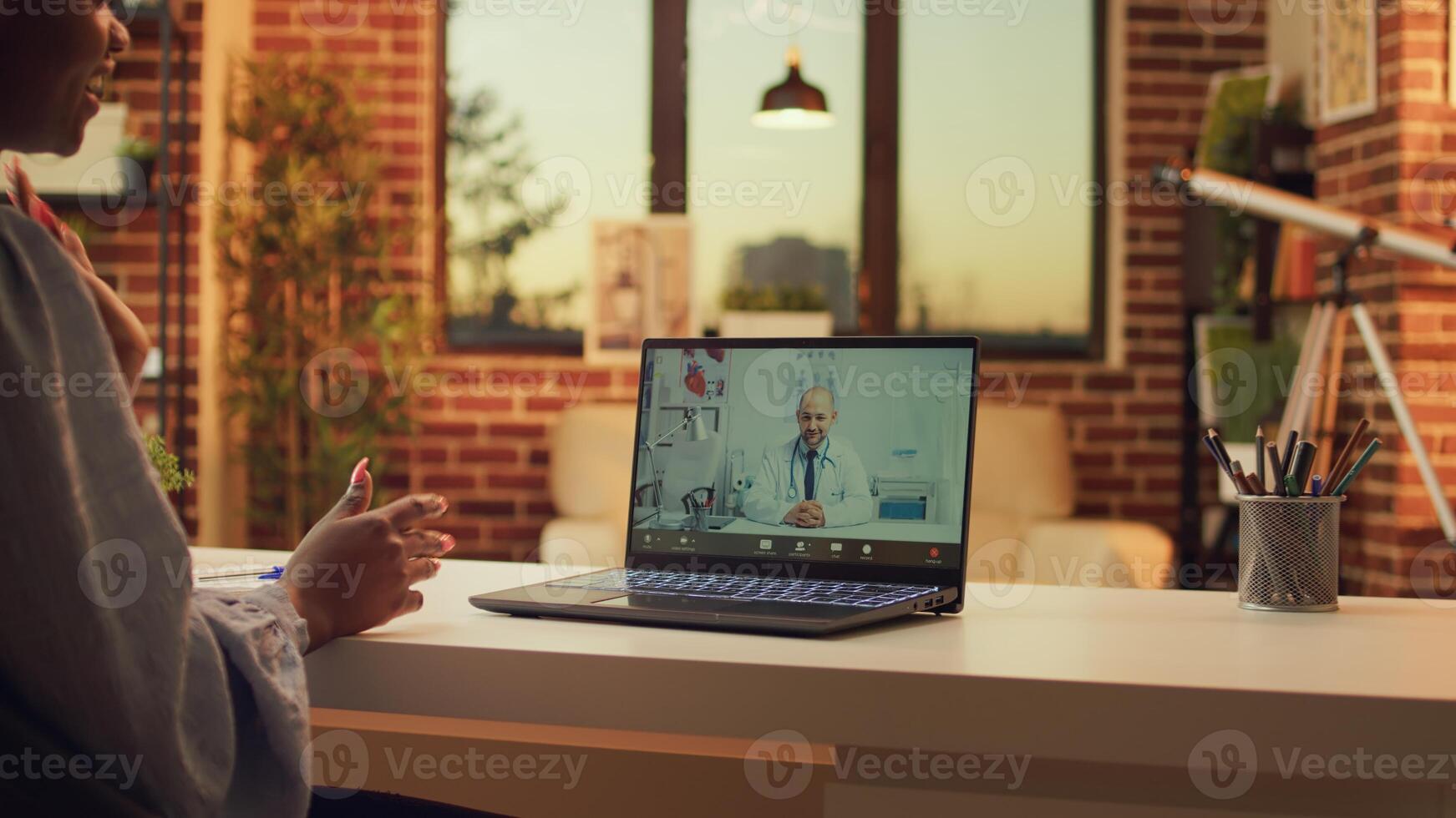 Person using telemedicine videocall with doctor asking for medical counselling and advice from home desk. Woman meeting with medic on telehealth conference to do checkup, medical service. photo