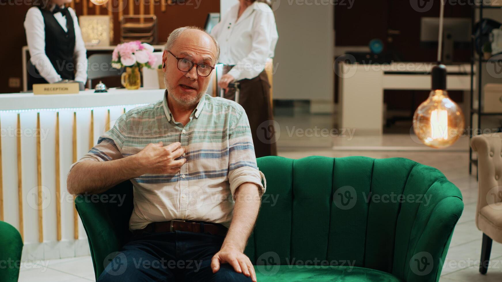 POV of elderly adult on videocall waiting for room check in, talking to family members about retirement holiday abroad. Tourist discussing with people on online remote videoconference. Tripod shot. photo