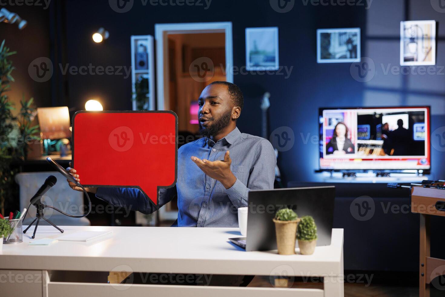 Man filming sponsored content, holding empty copy space sign in hand, following given script while talking to audience. Media star using cardboard bubble speech cutout to do promotion to viewers photo