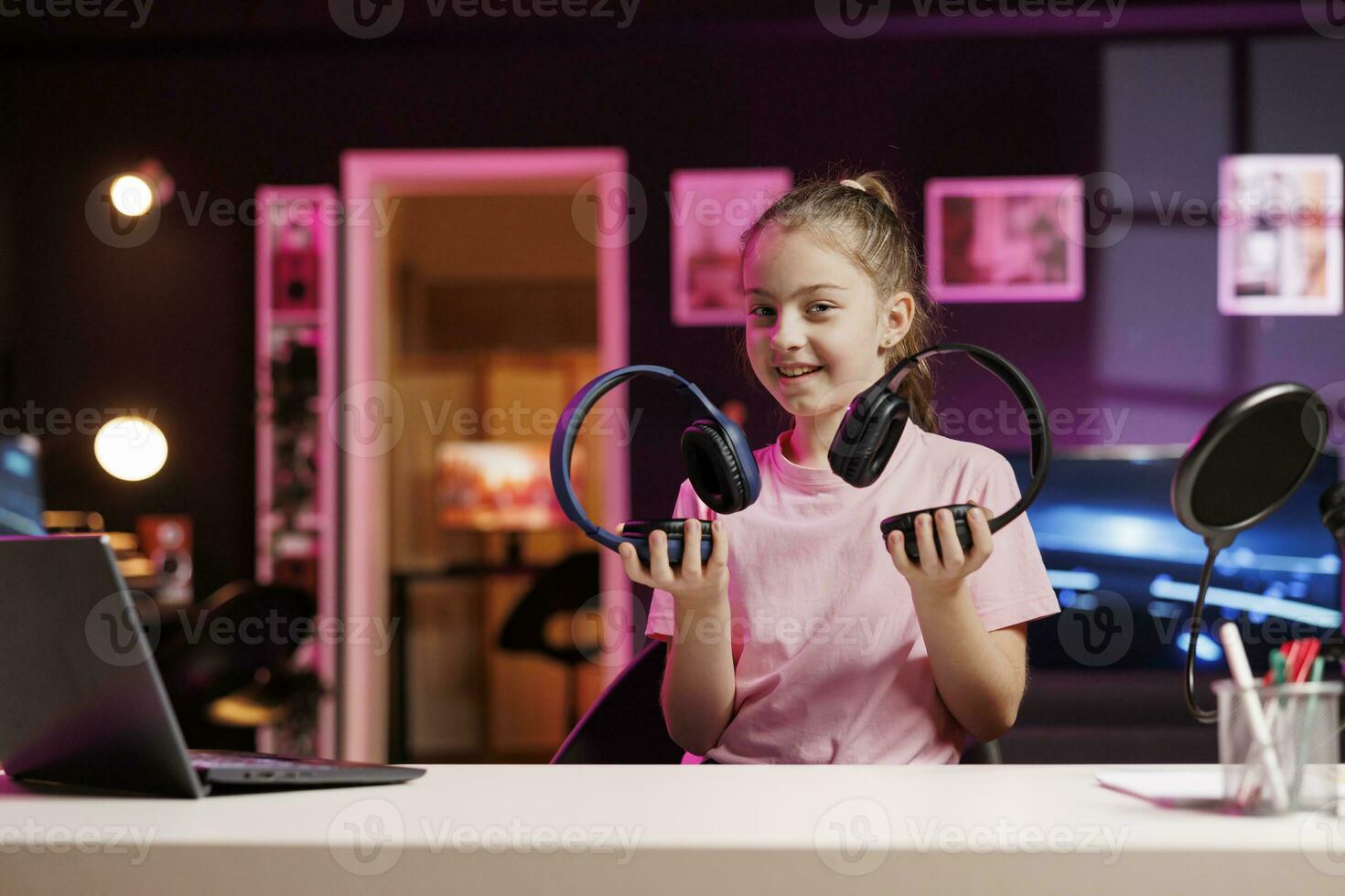 Generation Z technology media star filming headphones review, comparing maximum volume on both pairs. Cute girl showcasing audio devices to audience, drawing sound quality parallels between items photo