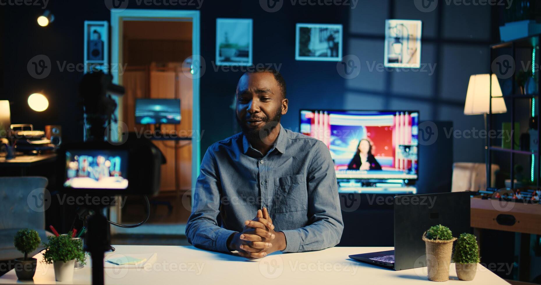 Cheerful influencer arrives in home studio, using professional camera to film live broadcast for digital platforms. Online star hosts q a session using recording gadgets, handheld camera shot photo