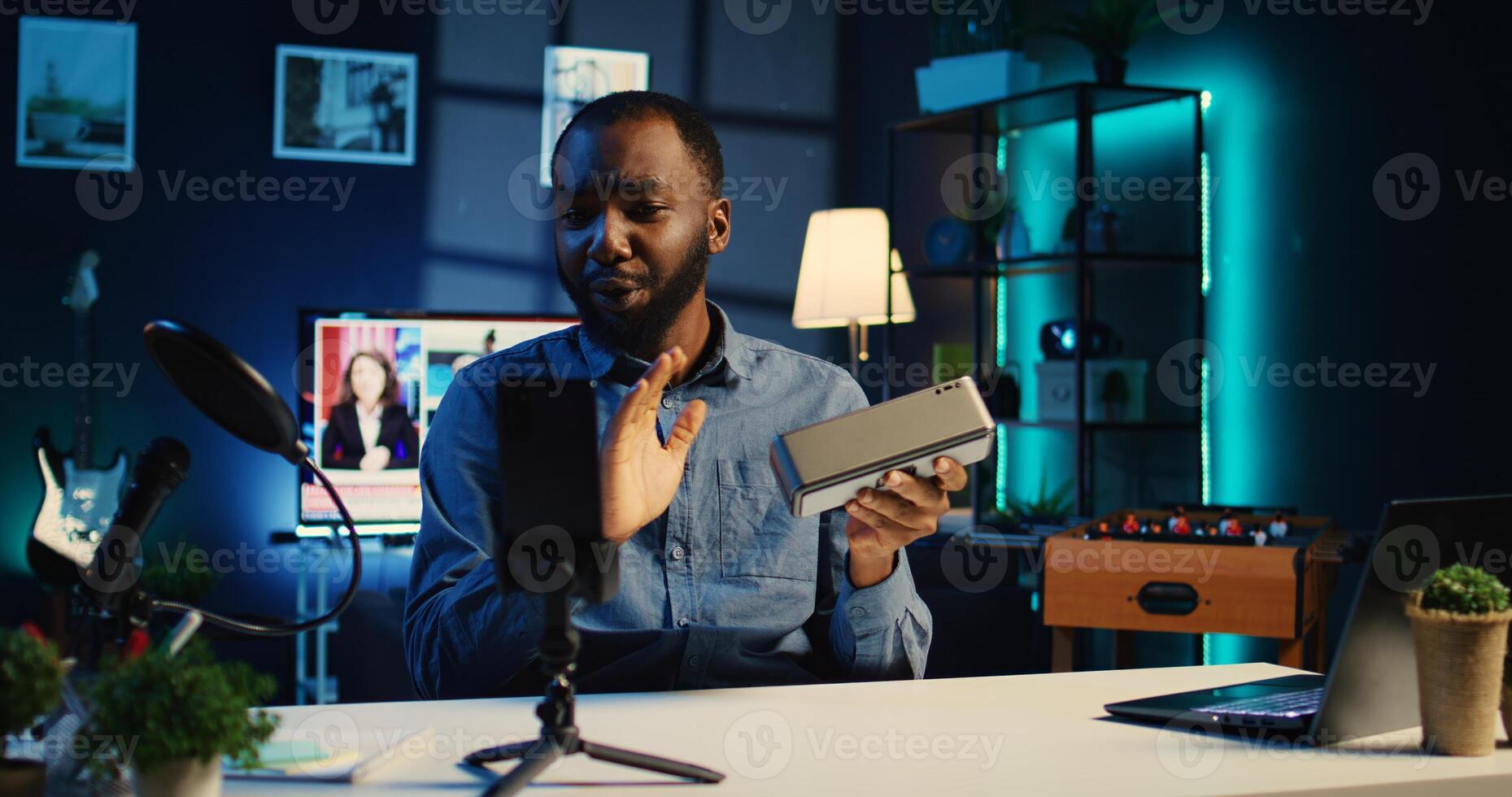 Content creator in studio films Bluetooth speaker video review for tech enthusiasts. African american viral online star hosts technology internet show, unboxing portable audio system photo