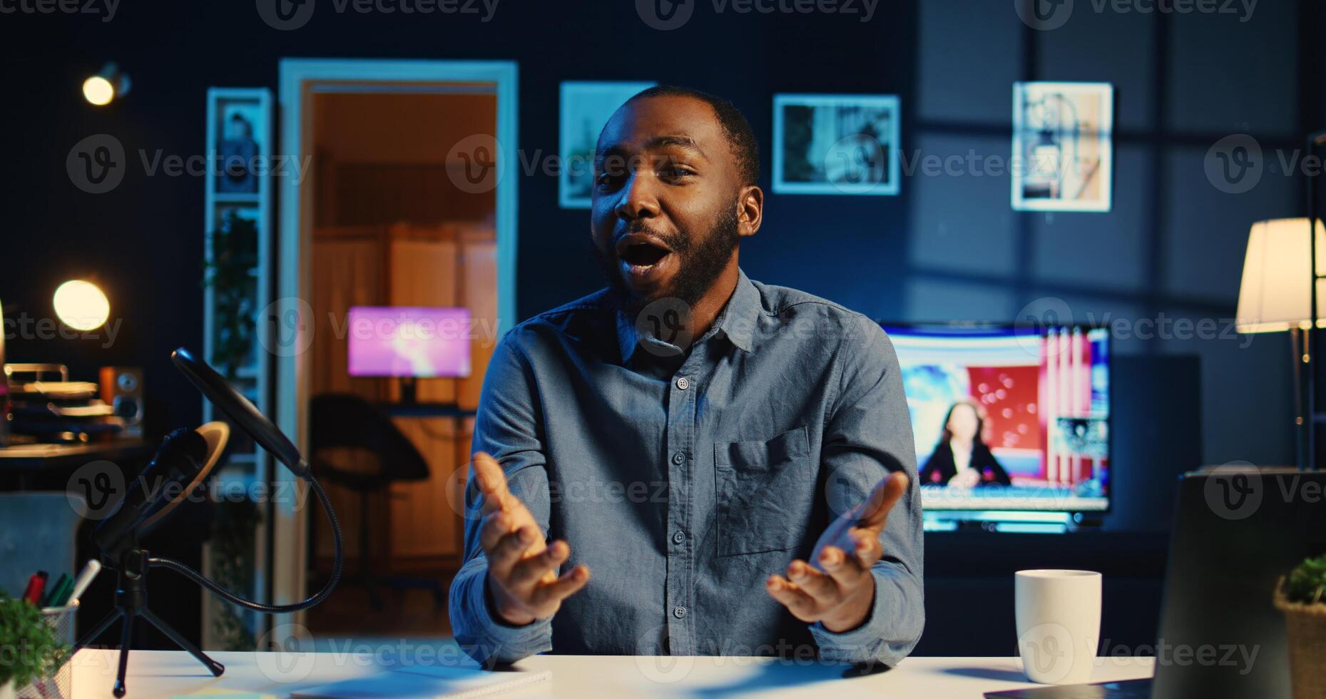 Happy influencer in home studio using professional camera and mic to film live broadcast for online streaming platforms, interacting with fans. BIPOC online star hosts q a session with viewers photo