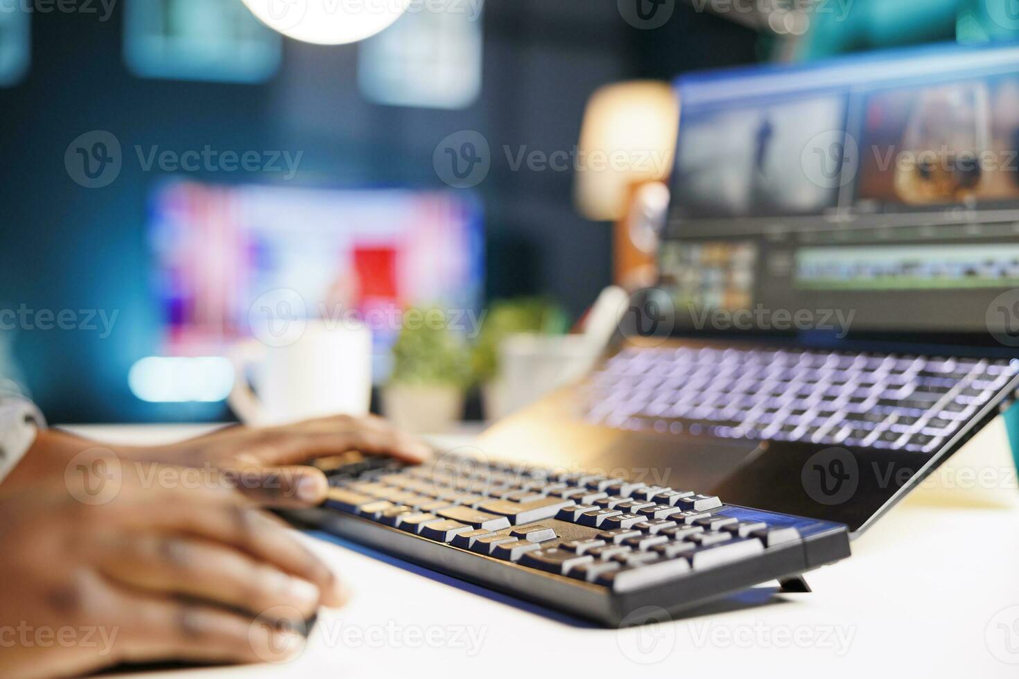 Close-up of African American individual edits footage on a laptop immersed in work, creating multimedia content. Image showing person utilizing modern technology for editing film montage. photo