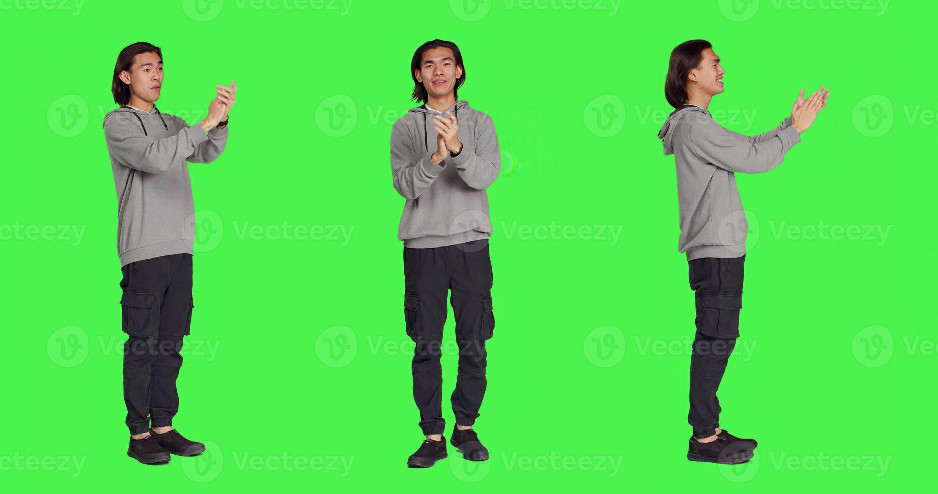 Asian happy guy applauding a person, clapping hands to show his congratulations and cheering for someone over full body greenscreen. Young man feeling optimistic and cheerful, standing ovation. photo