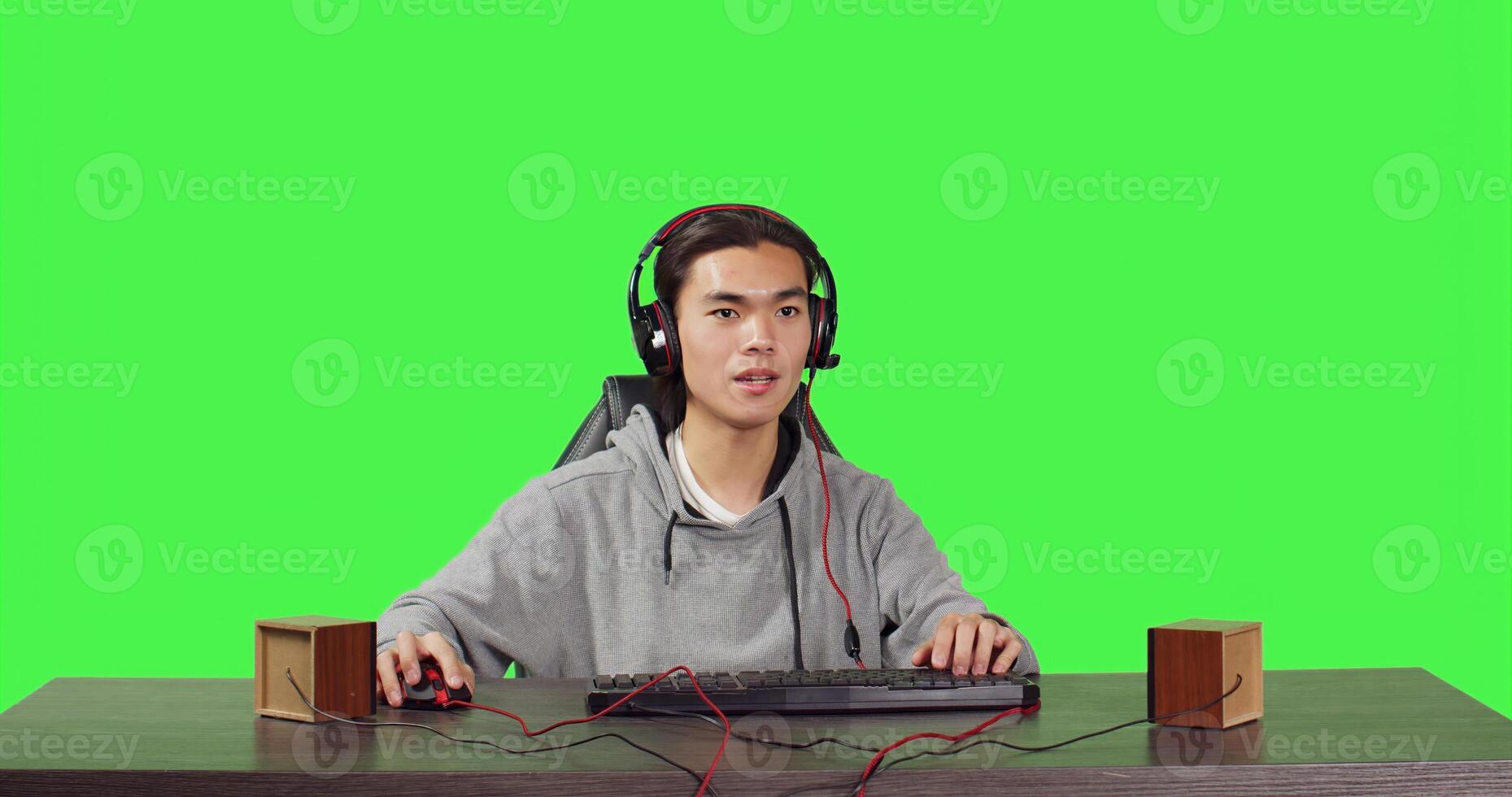 POV of adult enjoys web video games at pc while he talks to his colleagues on headphones, playing computer adventure gameplay at his desk. Young asian gamer having fun with tournament. photo