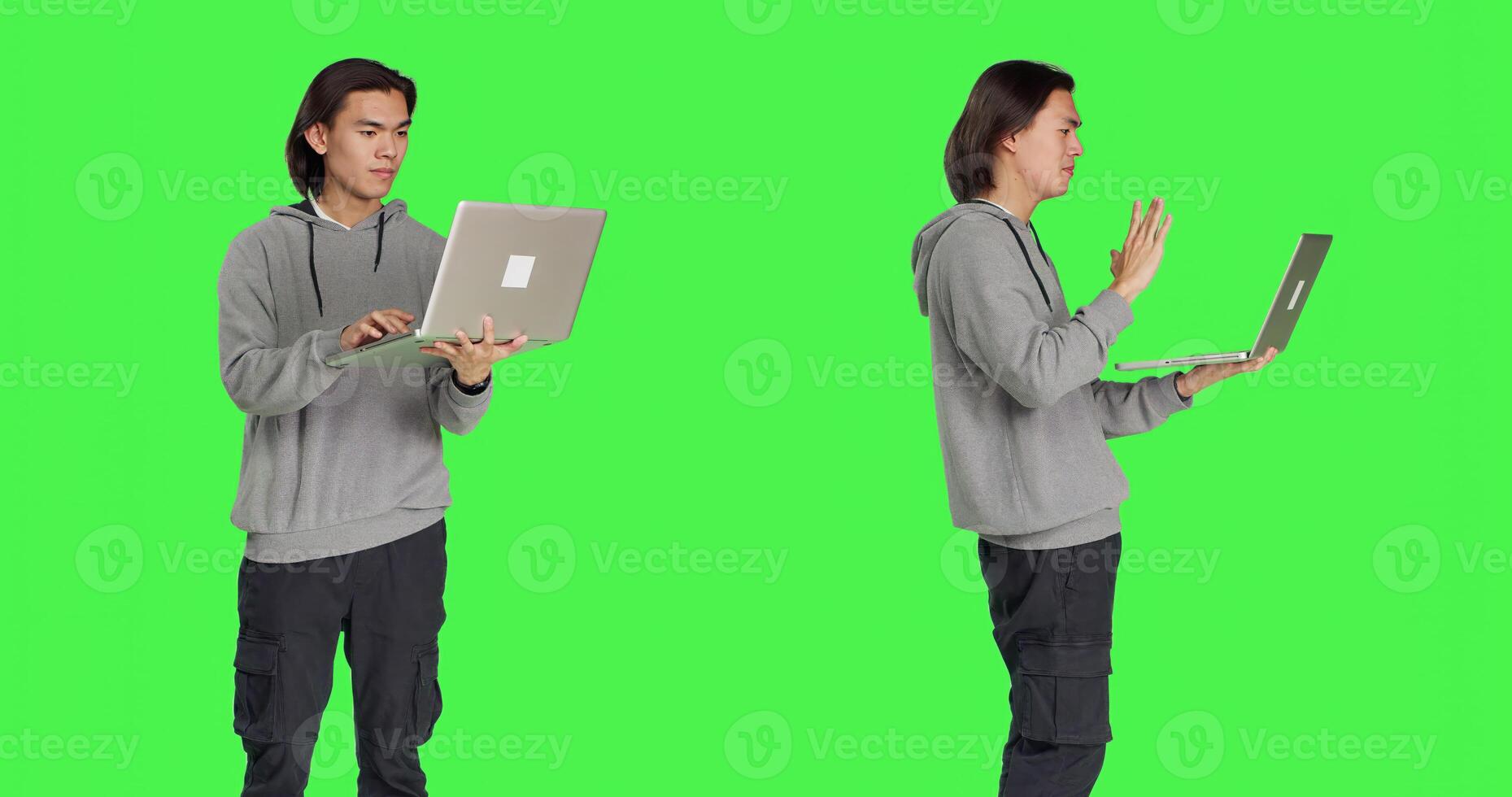 Young man greeting persons on videocall using laptop, interacting with people over an online conferencing. Against greenscreen, asian guy holds pc and chats with friends on teleconference. photo