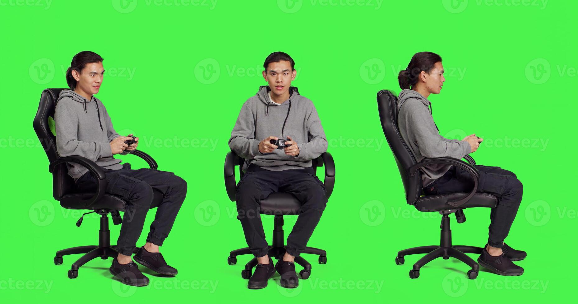 Asian adult enjoying video games over full body greenscreen, using controller and having fun with colleagues on online gaming contest. Young guy gamer playing multiplayer gameplay. photo