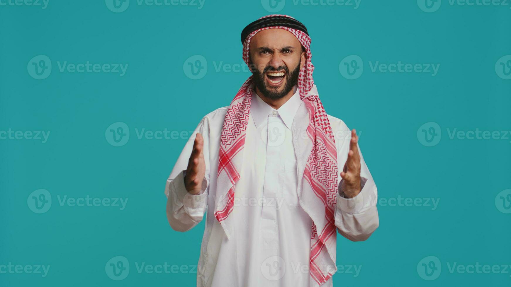 Confident man cheering and presenting his support in front of camera, feeling optimistic and happy about something. Middle eastern guy being brave and strengthening forces with cheers. photo