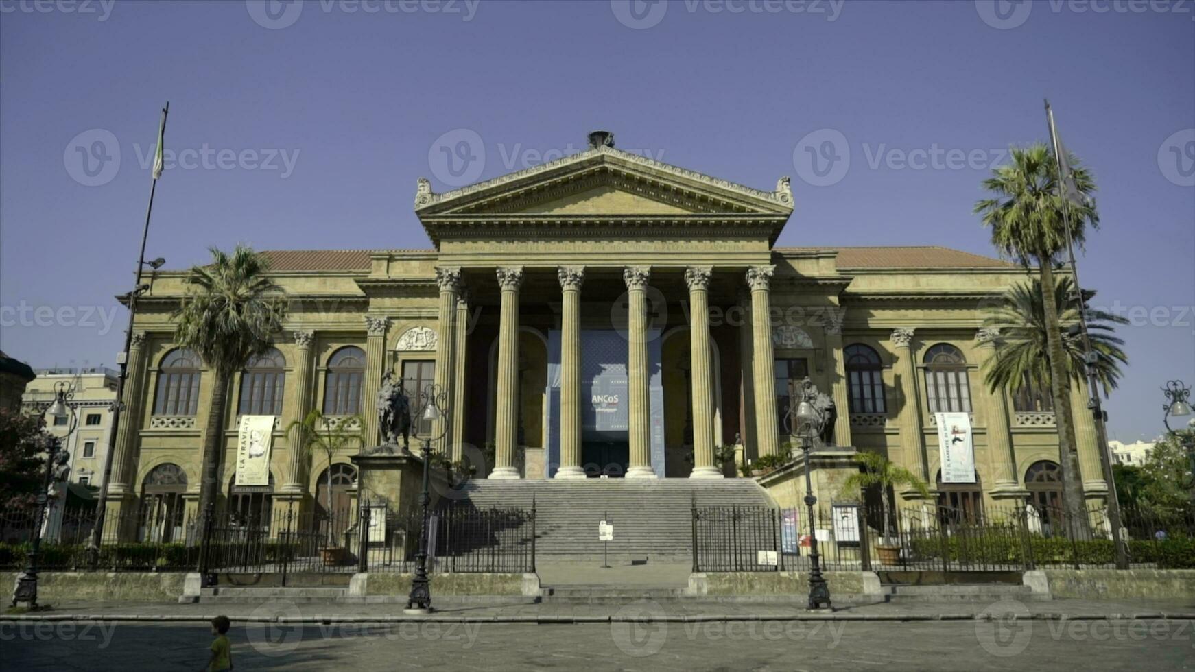 Facade of ancient building with columns and triangular portico. Action. Beautiful historical building with antique architecture and columns on blue sky background photo