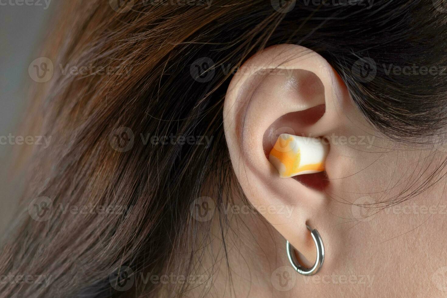 Earplugs for sleeping. Girl's ears close up photo