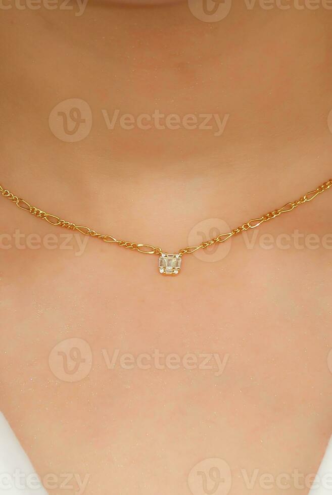 Young woman wearing a Figaro Chain Necklace containing a square zircon. photo