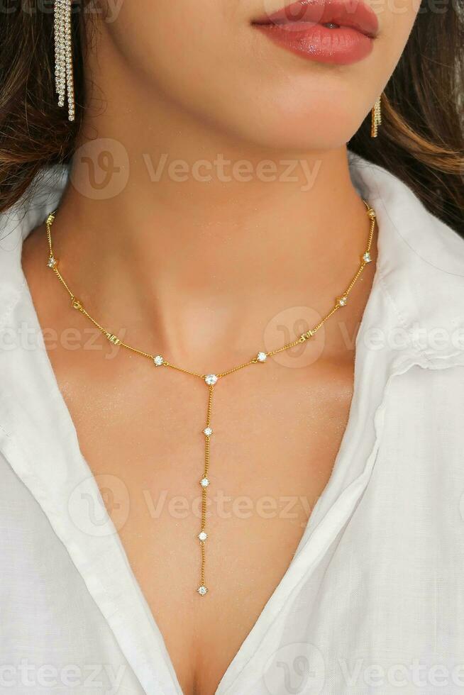 Young woman wearing a golden lariat necklace. photo