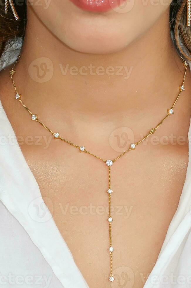 joven mujer vistiendo un dorado lazo collar. foto