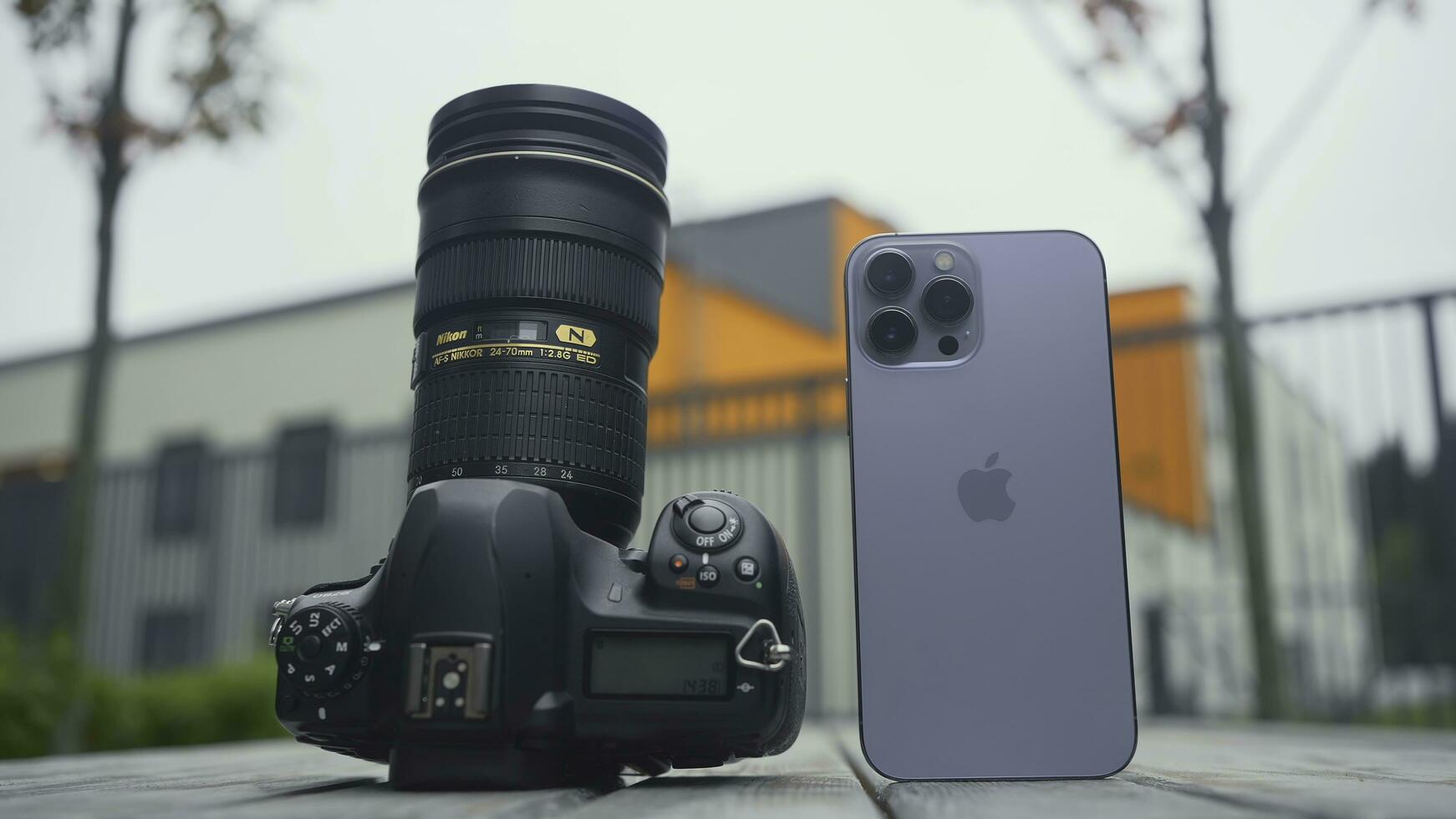 RUSSIA, MOSCOW - SEPTEMBER 27, 2021. Camera and phone comparison. Action. Professional camera with lens or new iPhone. Comparison of cameras of new iPhone 13 pro with professional camera photo
