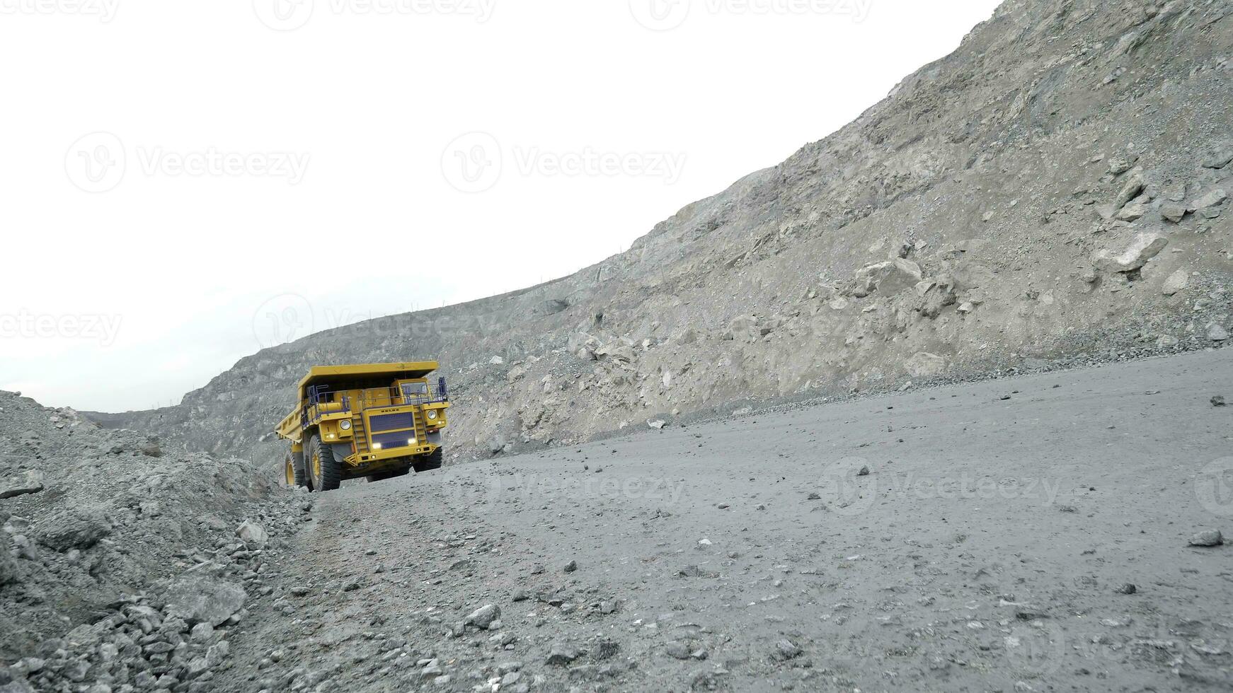 Moving of dump truck loaded with ore. Close-up of chalk quarry road. photo