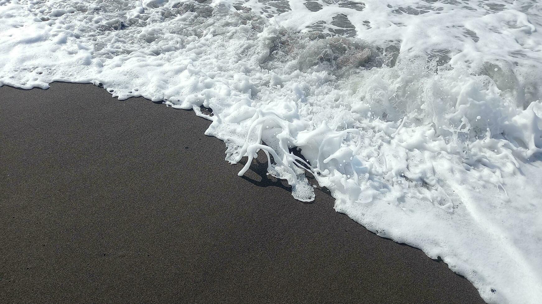 White waves at the beach. Wave motion at shore. Close up view of wave break up on the shoreline. photo