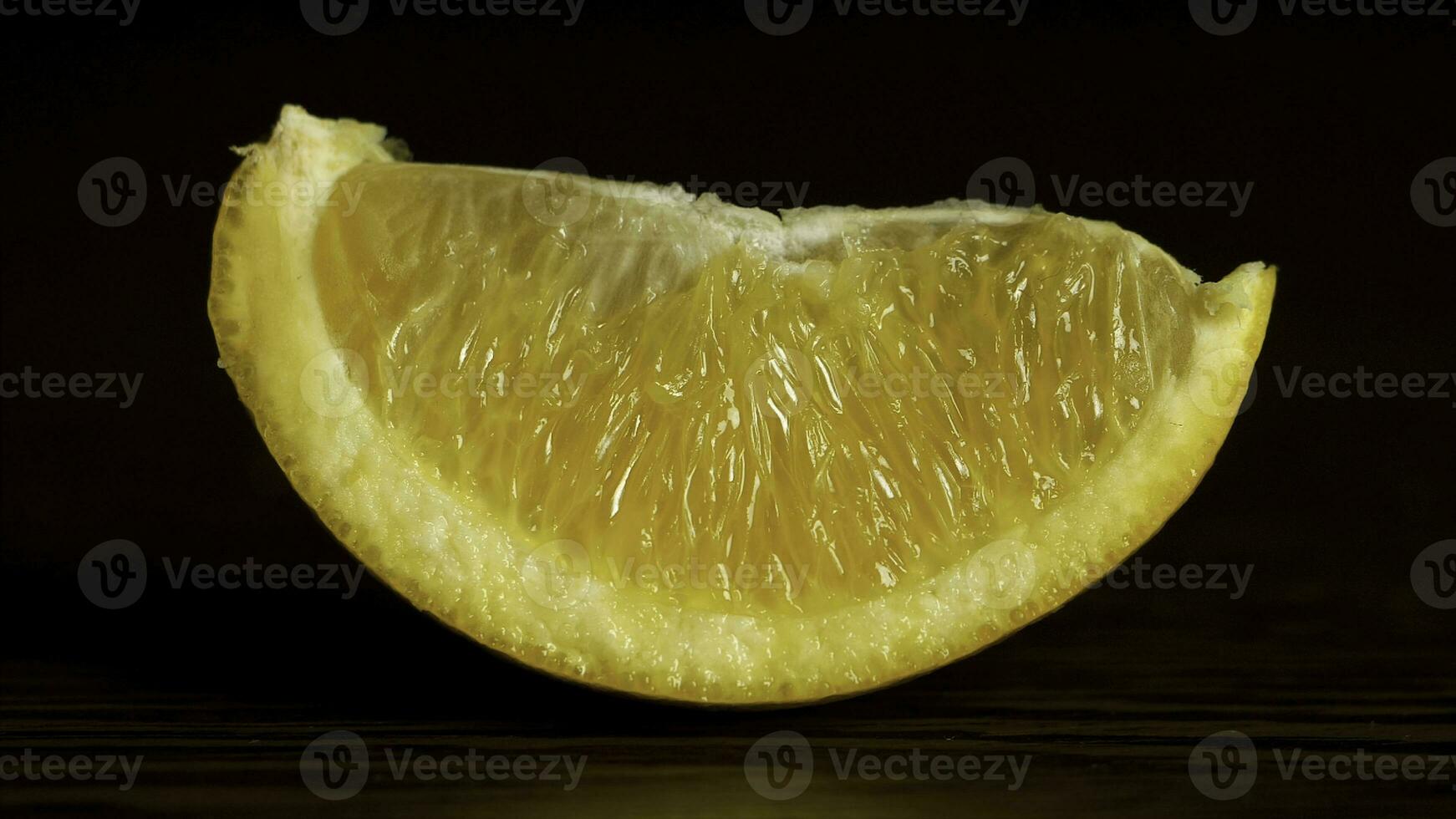 Juicy Fresh Fruit Orange Segments Against a Black Background. Fresh, juicy slice of orange rests on the table on a black background, the concept of proper nutrition photo