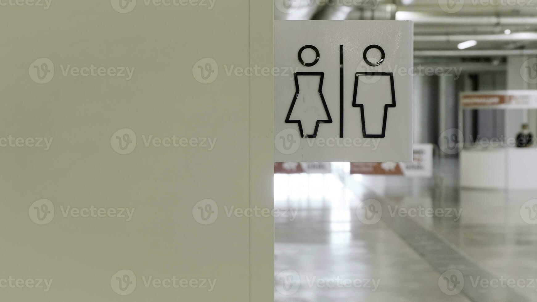 hombres y mujer baños firmar a el compras centro. hdr. parte de beige pared con masculino y hembra símbolos de un público baño. foto