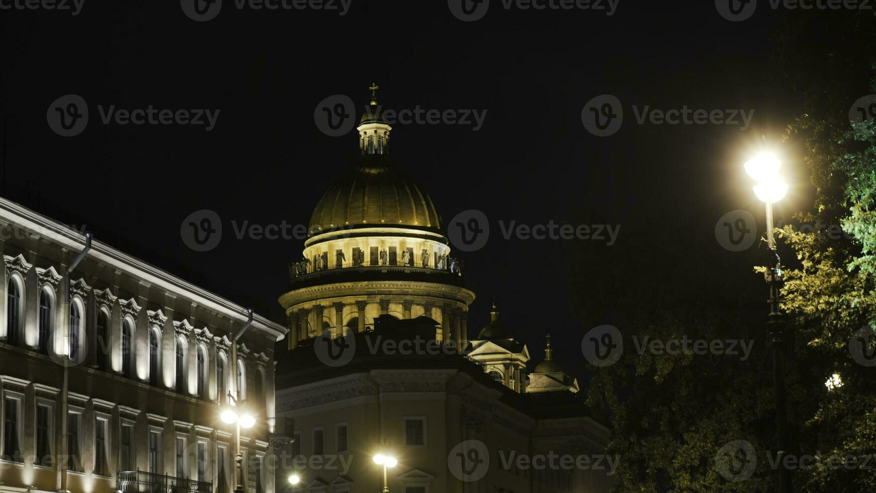Historical building with lighting on background of Cathedral at night. Action. Beautiful old architecture glows at night. Dome of Cathedral is brightly lit in night photo