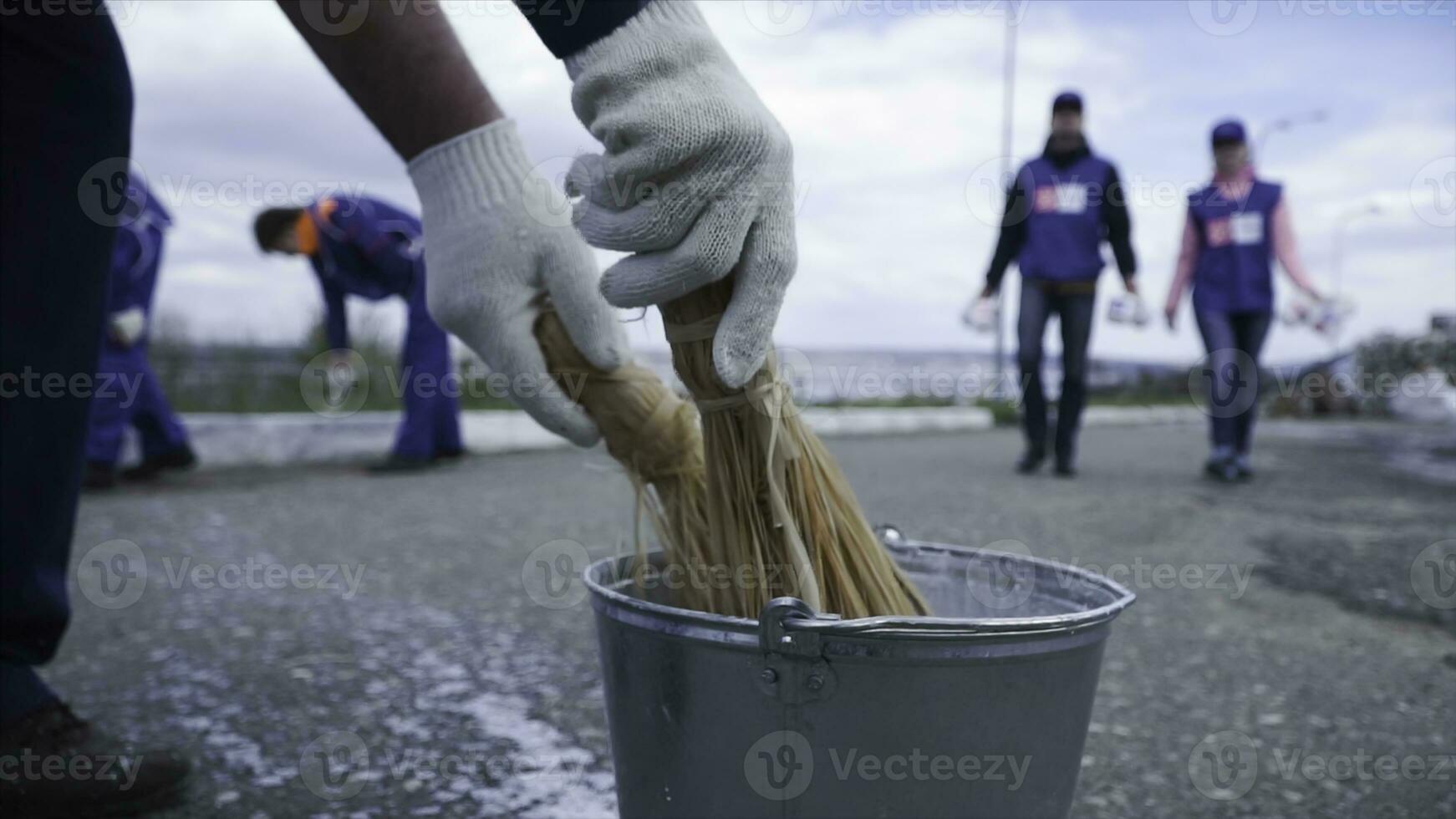 manos inmersión pintar dentro un lleno pintar taza. acortar. de cerca de un trabajador su cepillo dentro el pintar. trabajadores en azul inmersión el cepillo en el pintar foto