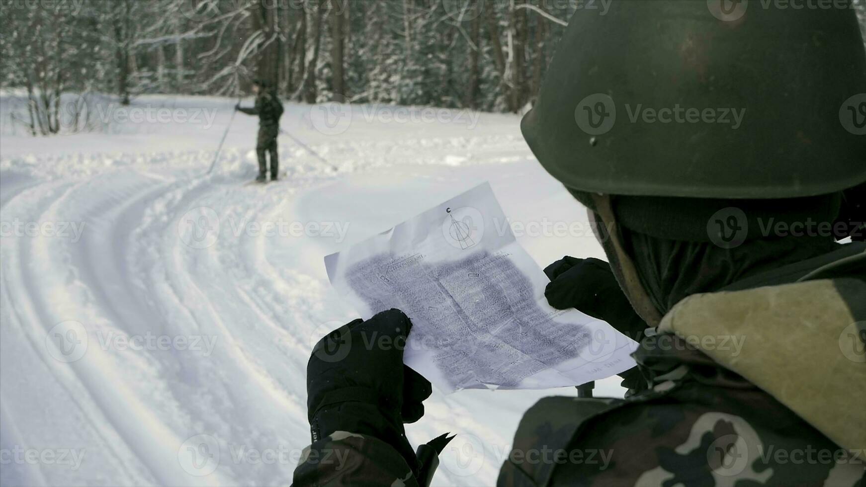 Soldier with weapons in cold forest. Winter warfare and military concept. Clip. Soldiers in winter forest on skis with guns. Military exercises in the forest in slow motion photo