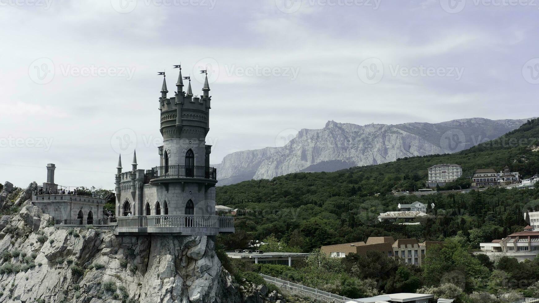 Aerial view of amazing Swallow's Nest at Gaspra in Crimea, Russia. Action. Fairytale castle built on the cliff top with green valley and blue sky on the background. photo