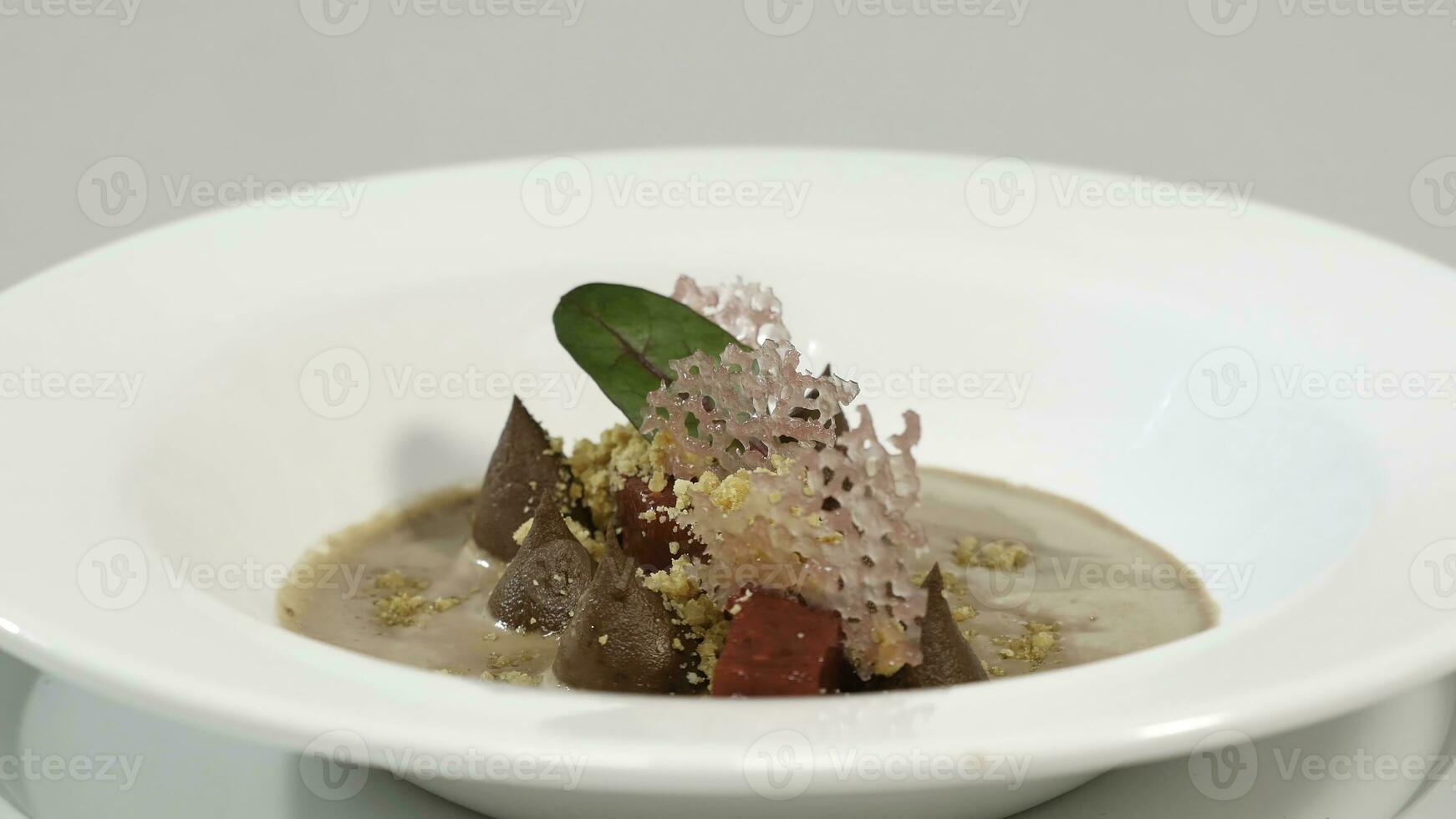 Beetroot salad. Salad with roasted beetroot, spinach, soft goat cheese and seeds in light plate over grey concrete textured background, oil in saucer. Top view photo