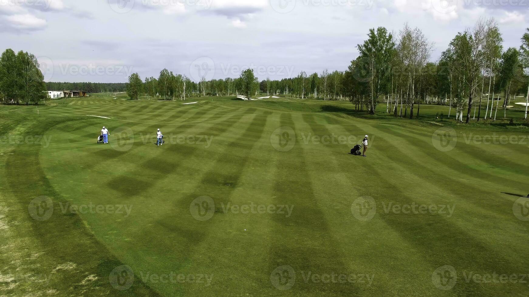 Aerial view Golf course. Golfers walking down the fairway on a course with golf bag and trolley photo