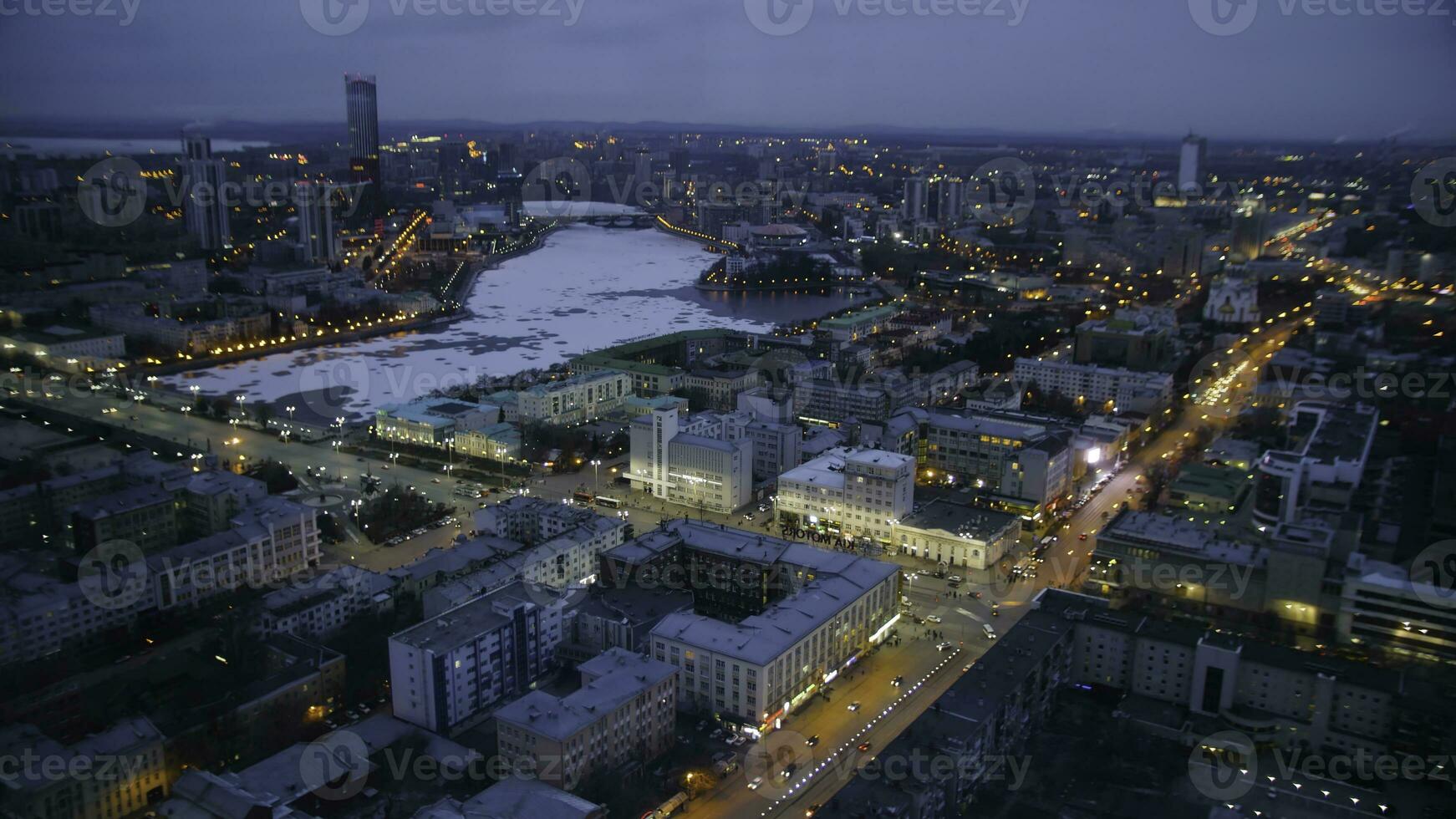 rascacielos con iluminación en ciudad a noche, parte superior ver desde uno edificio. noche ciudad con rascacielos parte superior vista. lapso de tiempo foto