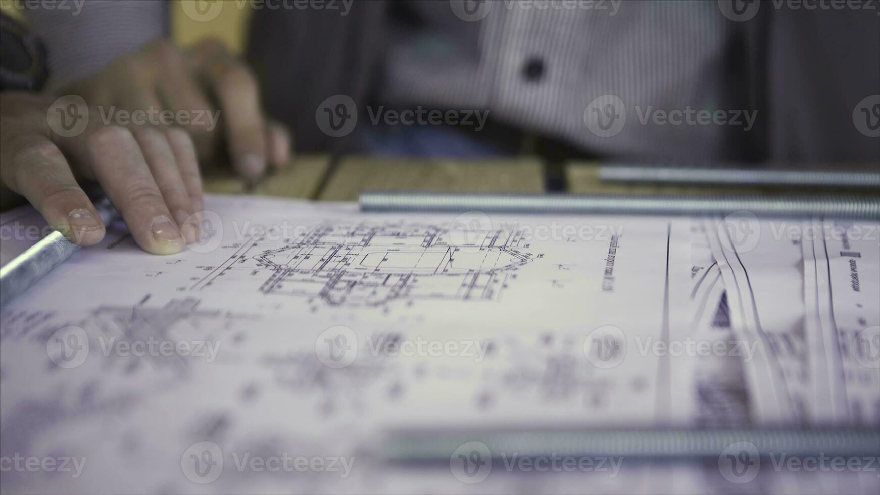 Close up view on engineer hand pointing at technical drawings. Men hands indicating some details in papers, blueprints with building project. photo