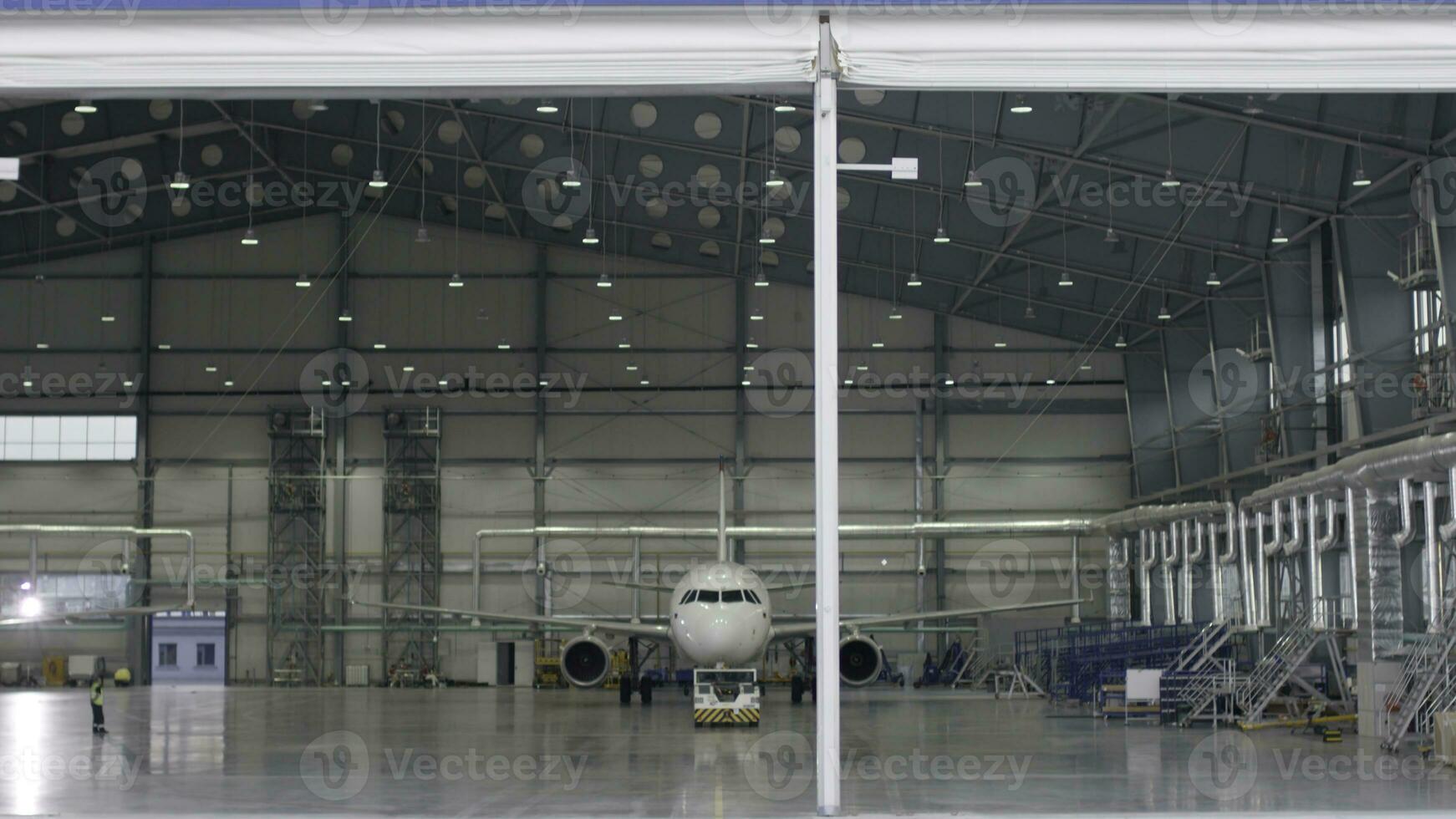 Roller shutter door and concrete floor of airport hangar and airplane background. Airport hangar from the outside with big tall doors. Front view. Aircraft Hangar photo