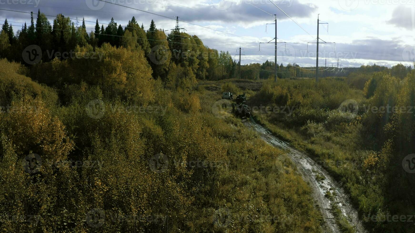 Riding a quad bike along the fields. Clip. Aerial view of autumn forest on a cloudy sky background, active lifestyle. photo