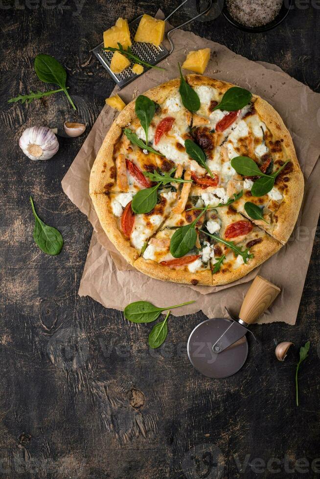 Italian pizza with feta cheese, tomato and basil photo