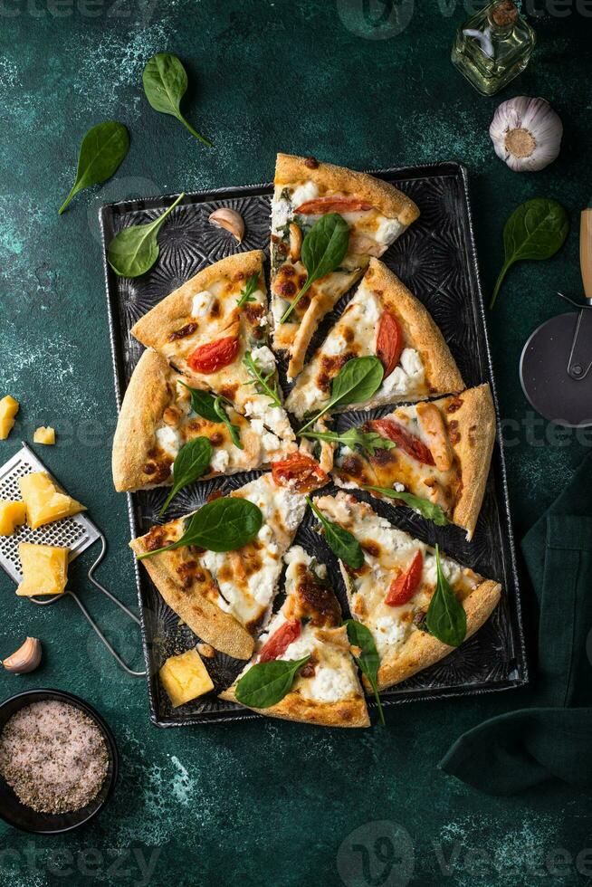 Italian pizza with feta cheese, tomato and basil photo