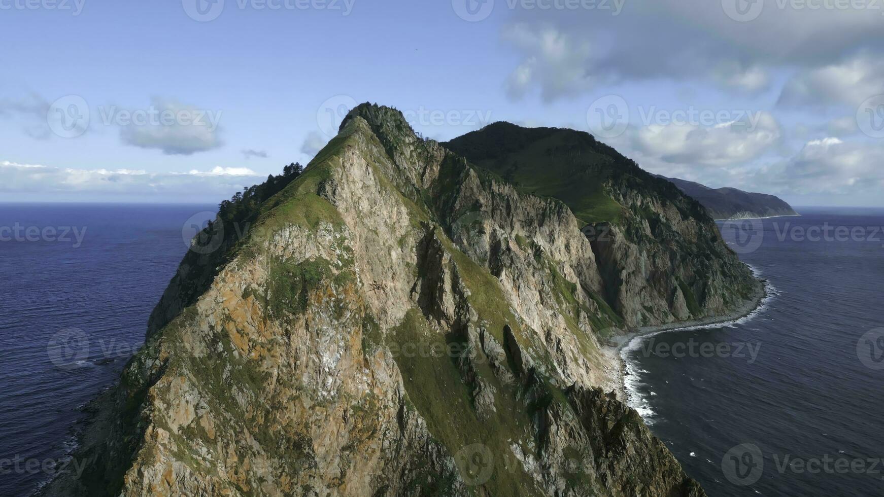 Top view of rocky mountains islands in ocean. Clip. Fabulous landscape of rocky island in ocean on sunny day. Cinematic landscape of rocky cape of island in sea photo
