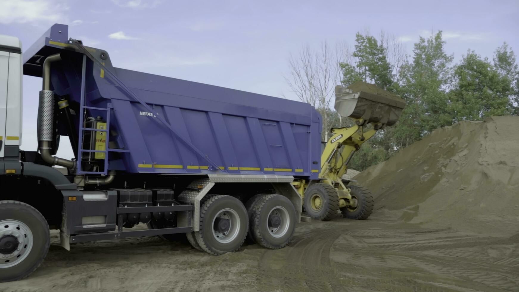 Berlin, Germany - June 20, 2022. Different machines work at a stone quarry. Scene. Industrial background with tractors and trucks loading stones and sand. photo